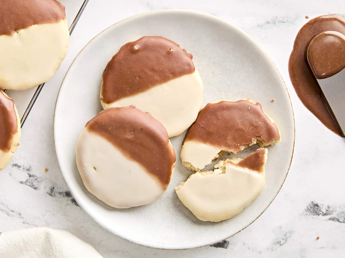 Vue aérienne de biscuits noirs et blancs sur une assiette, dont un est cassé en deux.