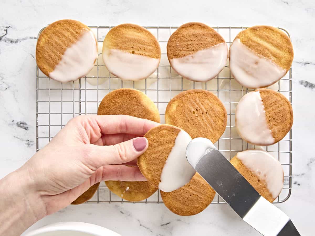 Biscuits noirs et blancs glacés à moitié avec du glaçage blanc.