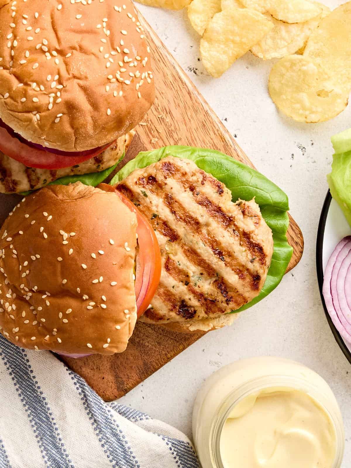Vue aérienne d'un hamburger de poulet maison sur un plateau en bois.