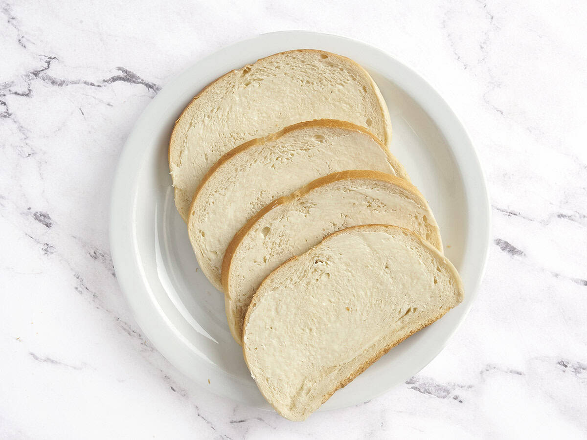 Quatre tranches de levain garnies de beurre.