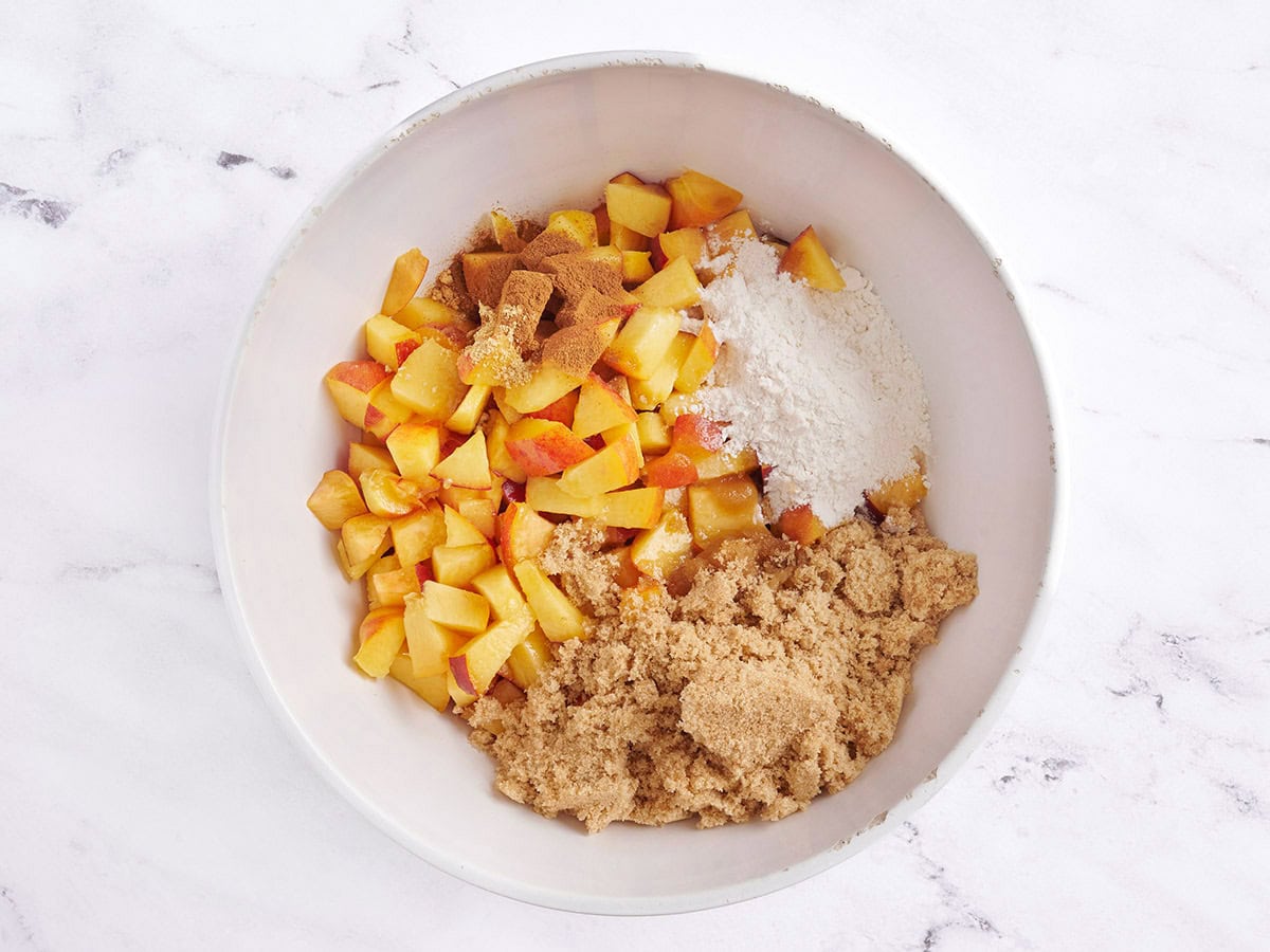 Pêches en dés et sucre dans un bol.