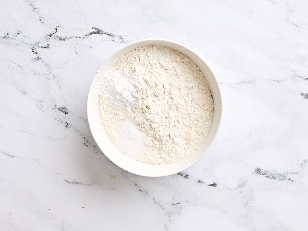 Les ingrédients secs pour le gâteau à la vanille dans un bol à mélanger.