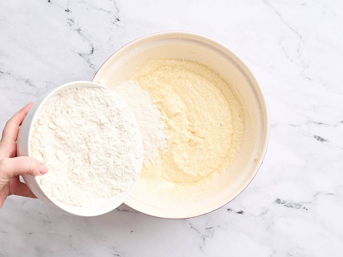 Les ingrédients secs sont combinés avec les ingrédients humides dans un bol pour faire du gâteau à la vanille.