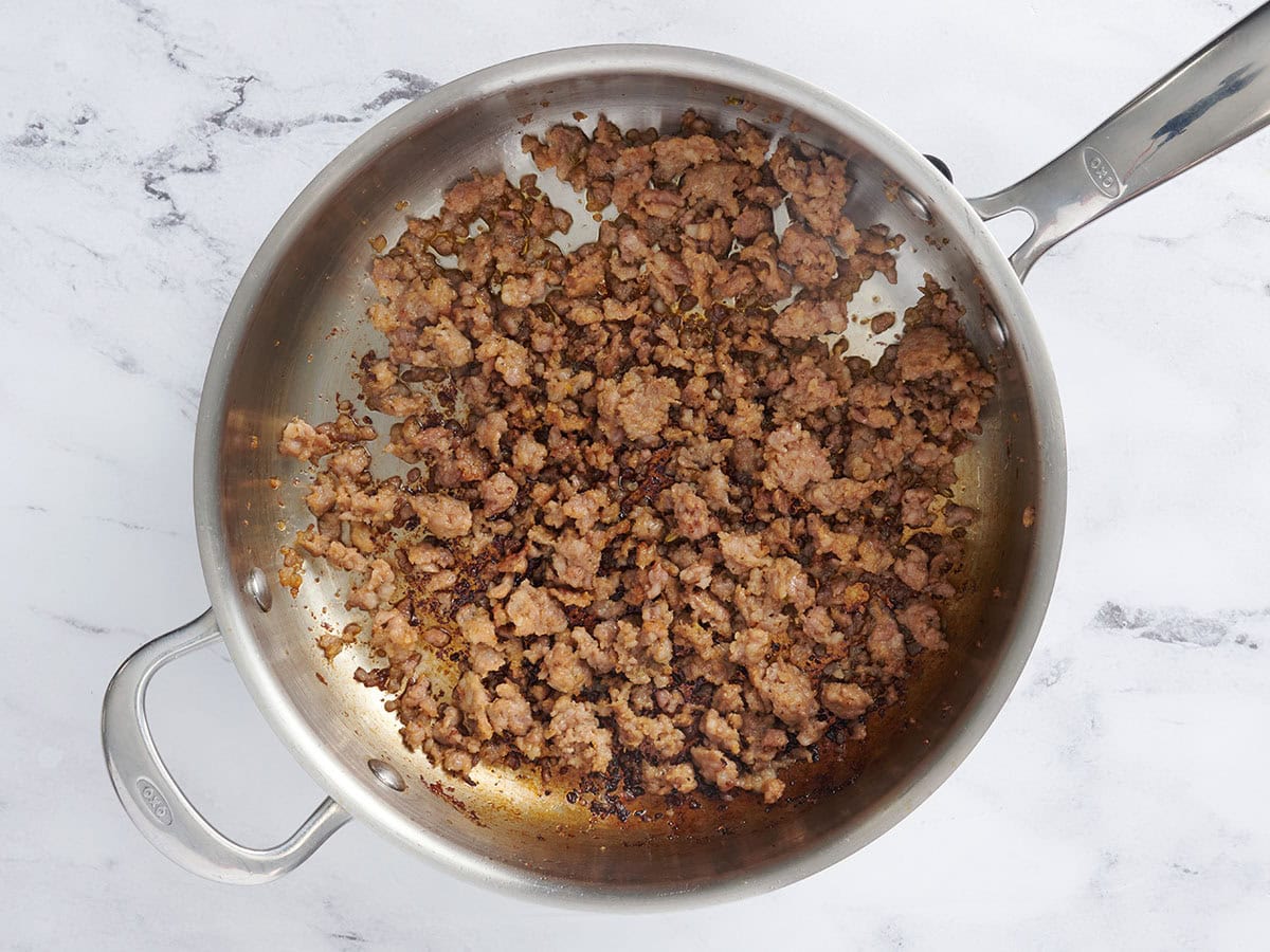 Saucisse dorée dans une poêle.