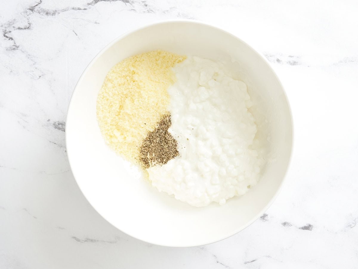 Fromage cottage, parmesan et poivre dans un bol.