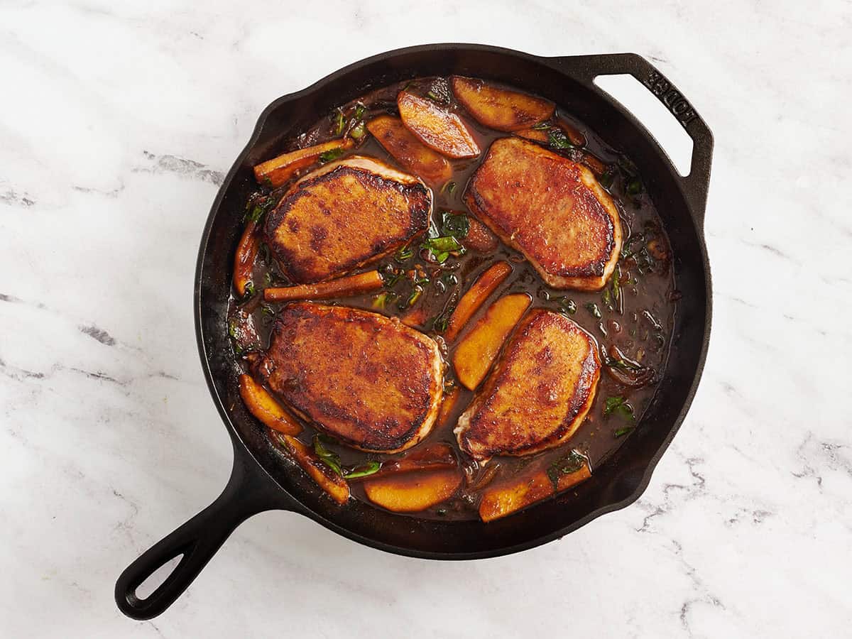 Coupure de porc au beurre de pomme dans une poêle.