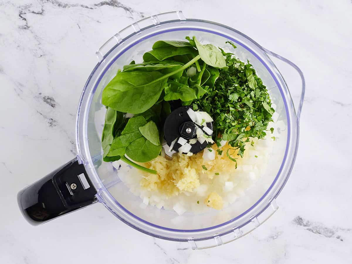 Épinards, oignon, ail et gingembre dans un robot culinaire.