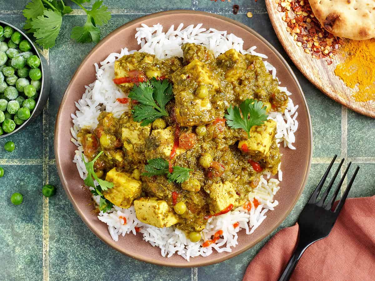 Vue aérienne d'un curry de tofu végétalien sur une assiette avec du riz blanc.