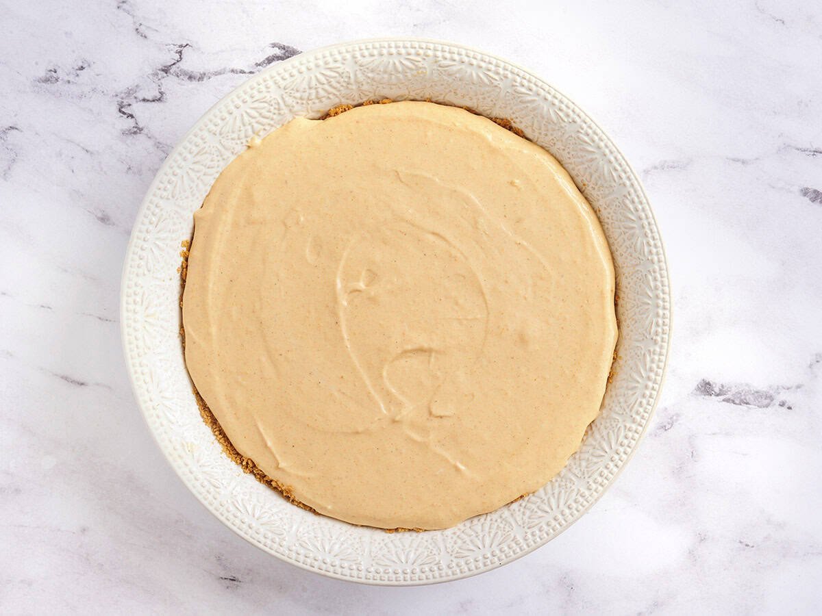 Cheesecake à la citrouille dans un plat à tarte avant la cuisson.