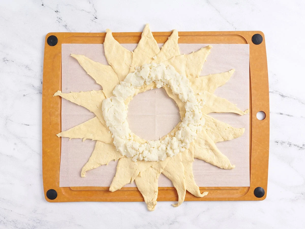 Placer la purée de pommes de terre à l’intérieur des rouleaux de croissant étalés. 