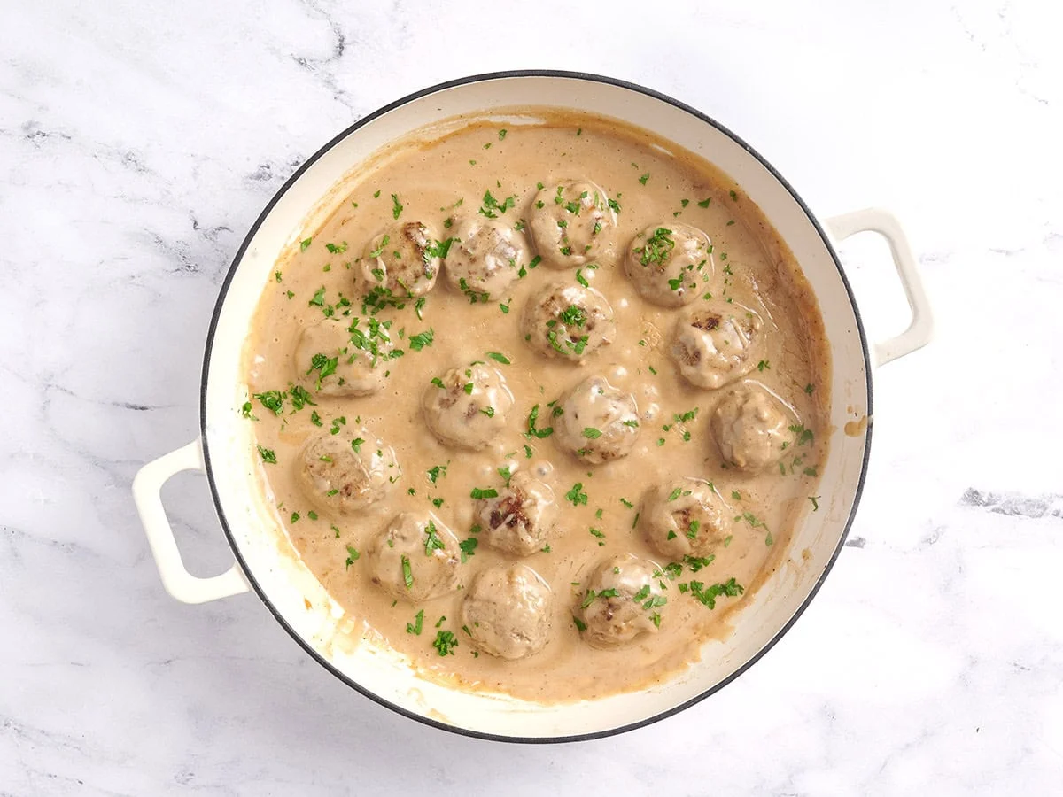Boulettes de viande suédoises faites maison dans une marmite garnie d'herbes fraîches.