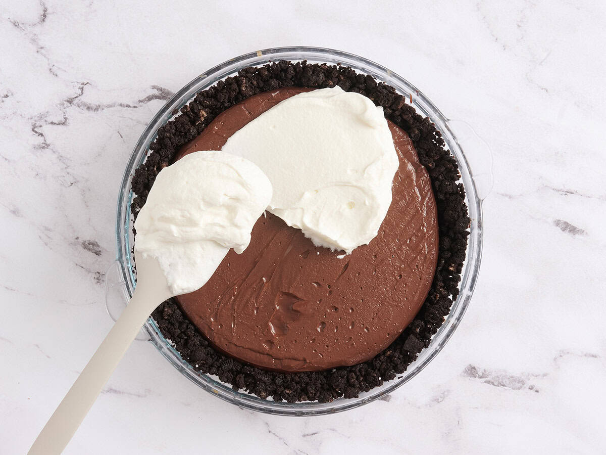 Crème fouettée étalée sur une tarte à la boue du Mississippi.