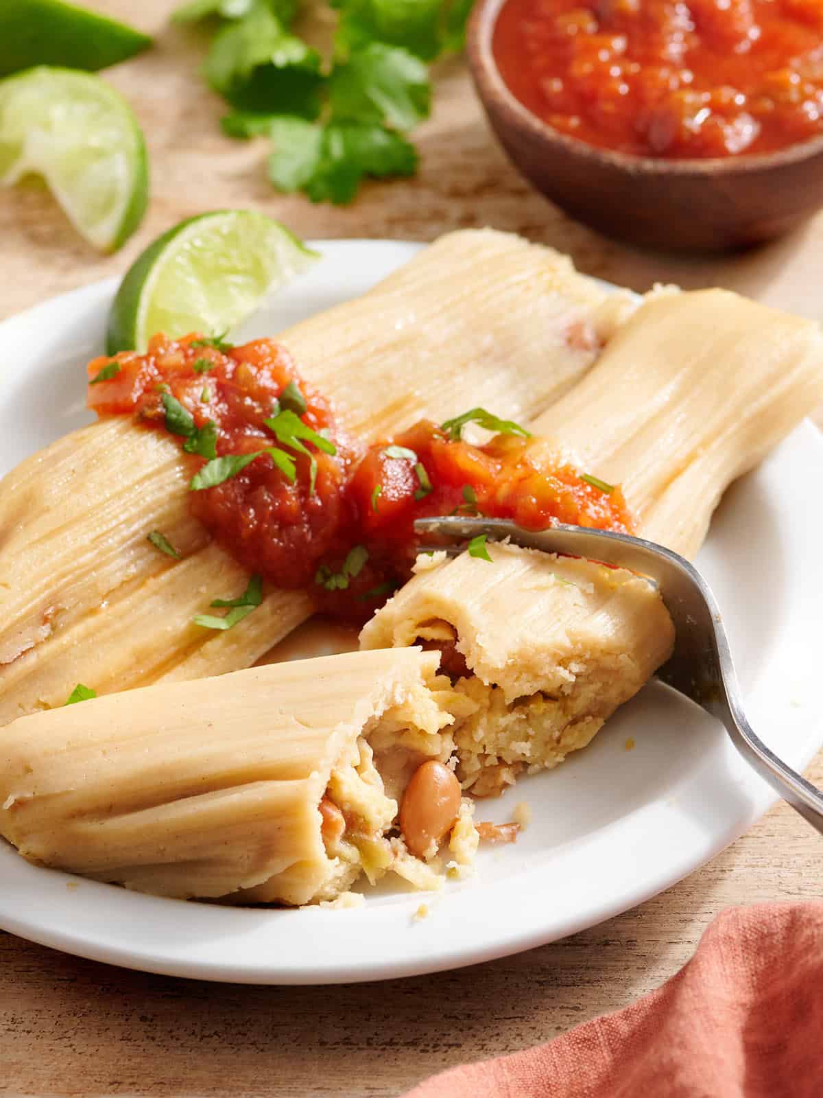 Vue latérale des tamales de haricots sur une assiette avec salsa.