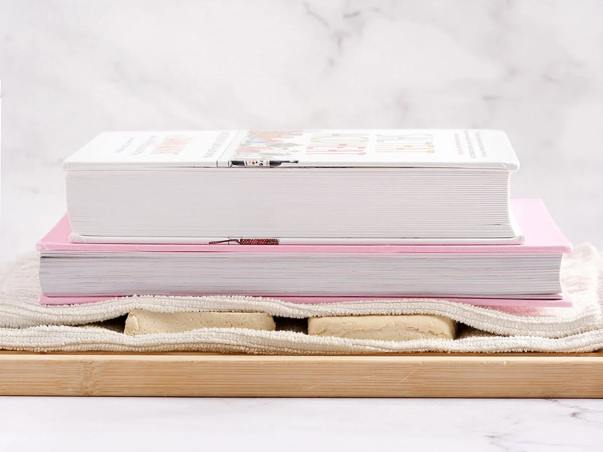 Tofu pressé avec des livres de cuisine.