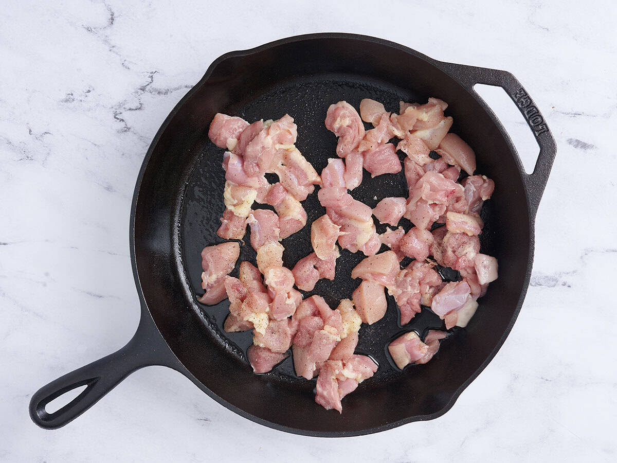 Cuisson des morceaux de cuisse de poulet dans une poêle.