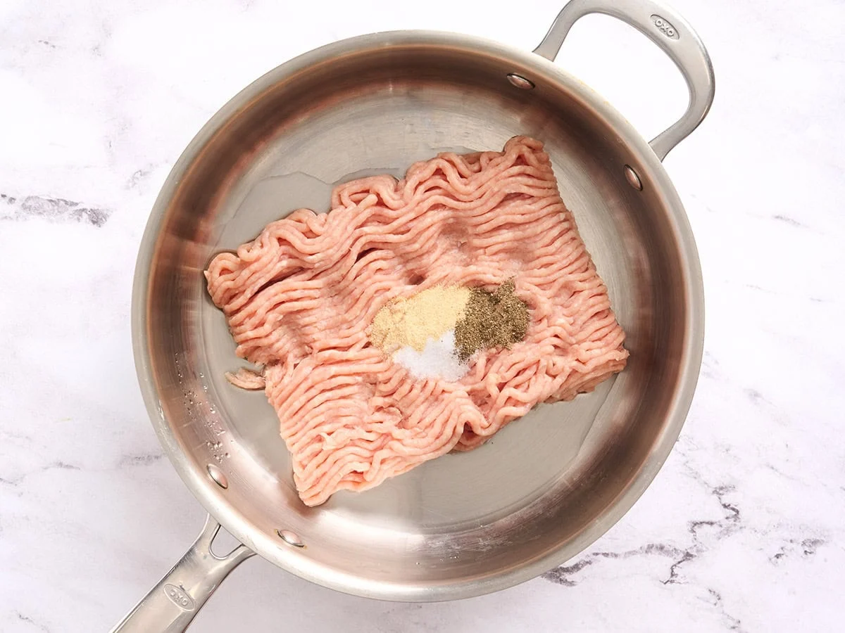 Poulet haché et assaisonnements dans une poêle.