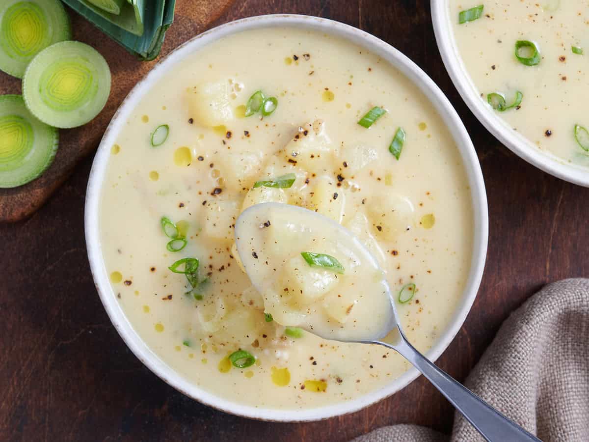 Overhead view of potato leek soup in a bowl with a spoon.