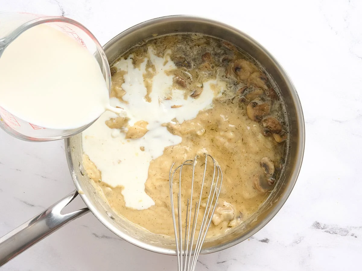 Le lait est versé dans une poêle avec un roux.