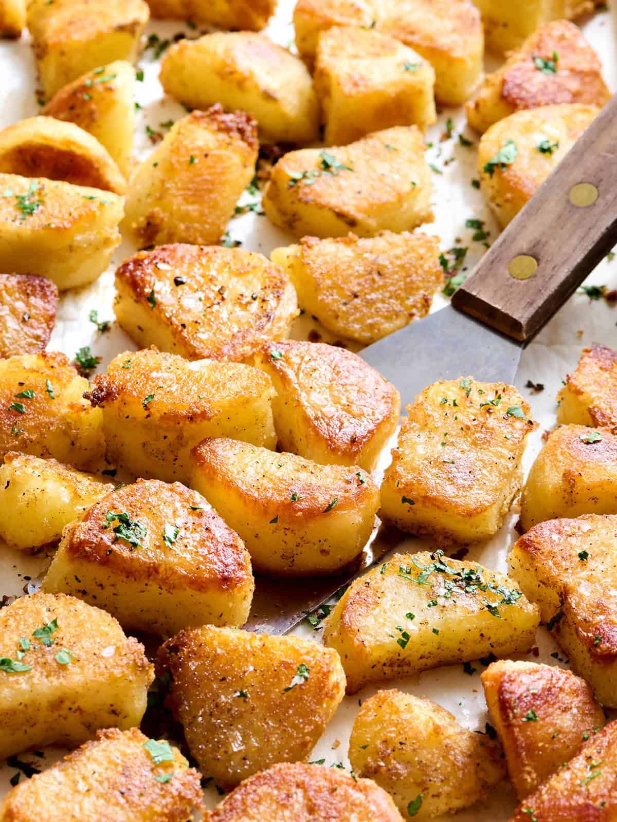 Pommes de terre rôties au four sur une plaque à pâtisserie avec une spatule.