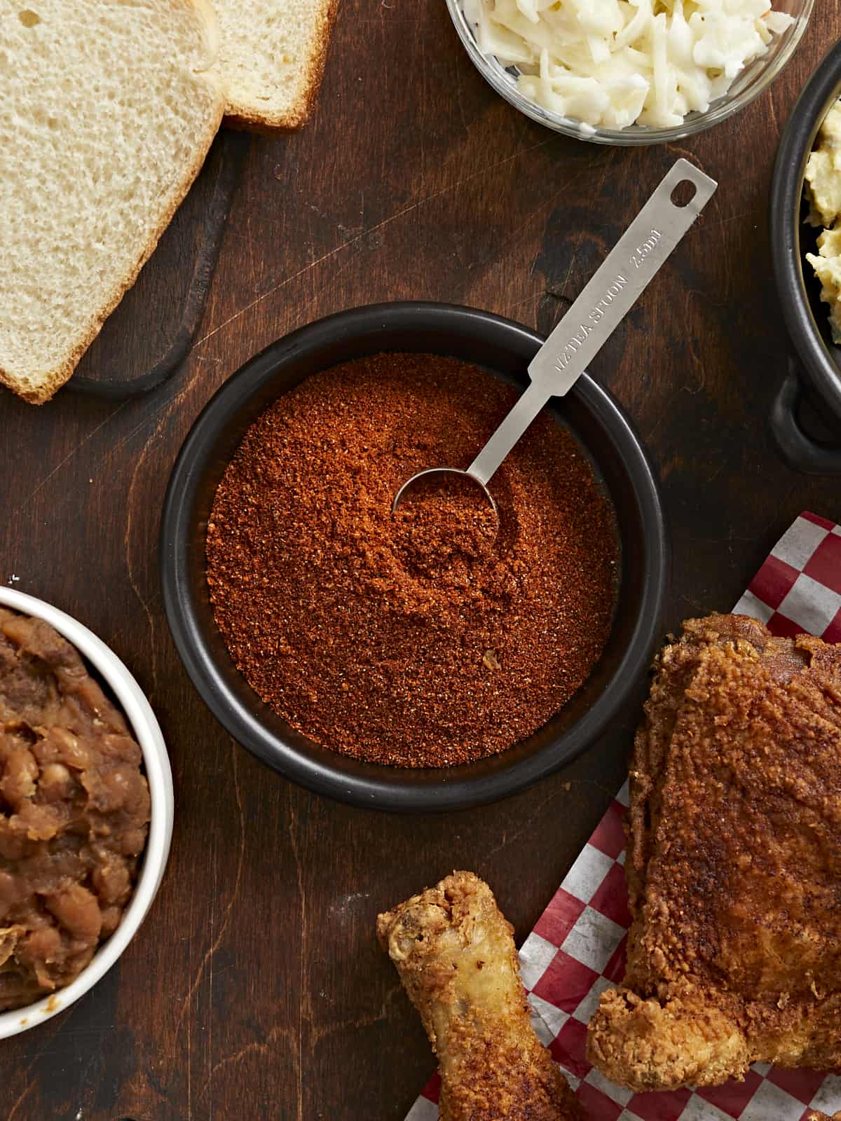 Photo aérienne de Nashville Hot Seasoning dans un bol noir contenant une cuillère à mesurer en argent.