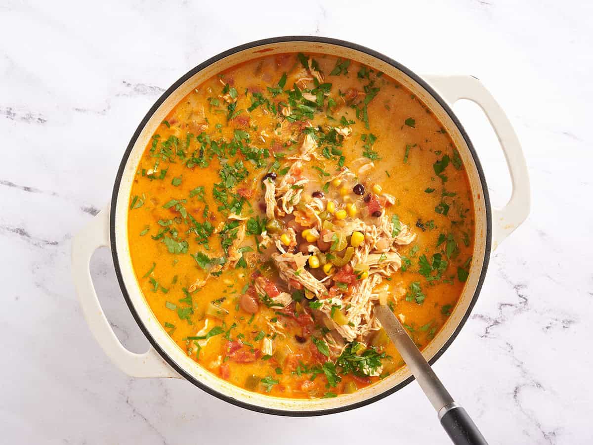 Poulet râpé ajouté à un pot de soupe taco au poulet maison.