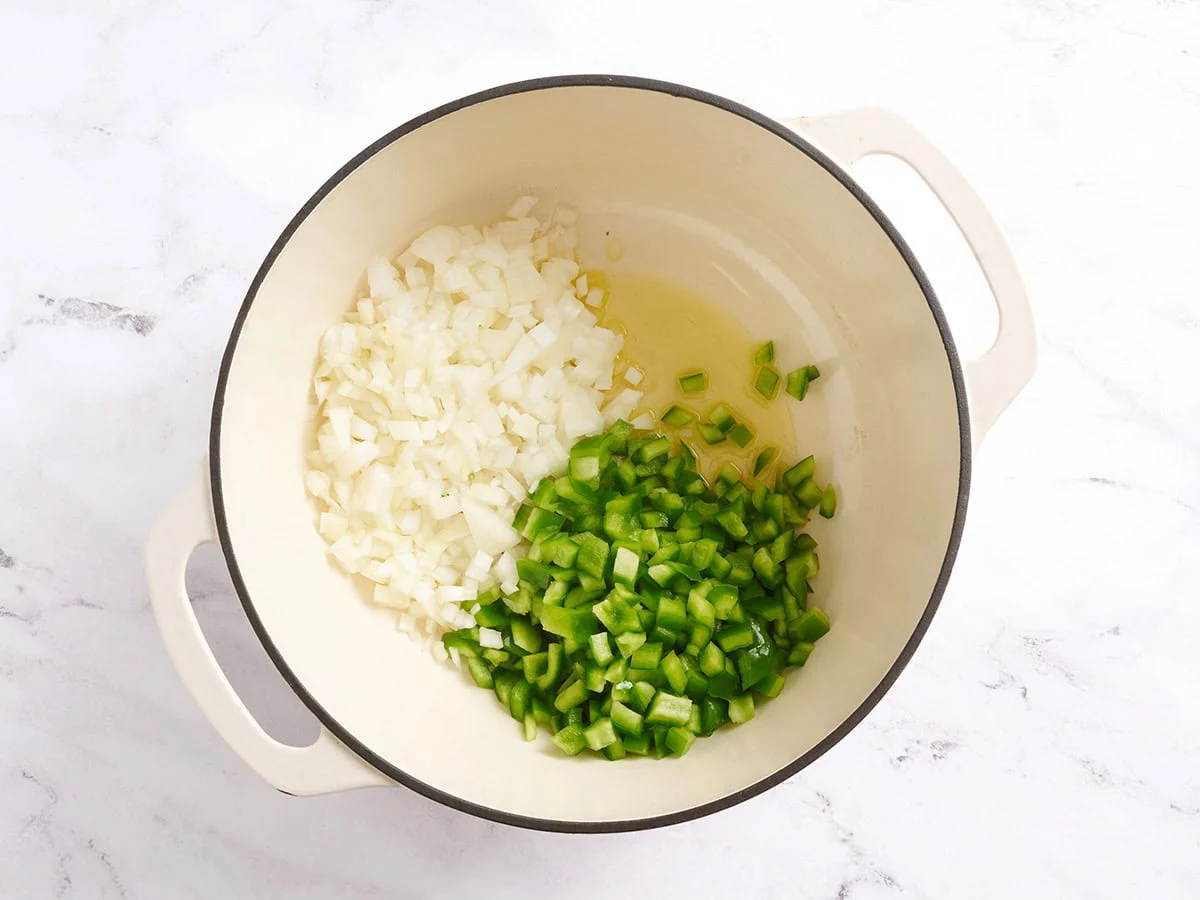 Oignon coupé en dés, poivron vert coupé en dés et huile dans une casserole.
