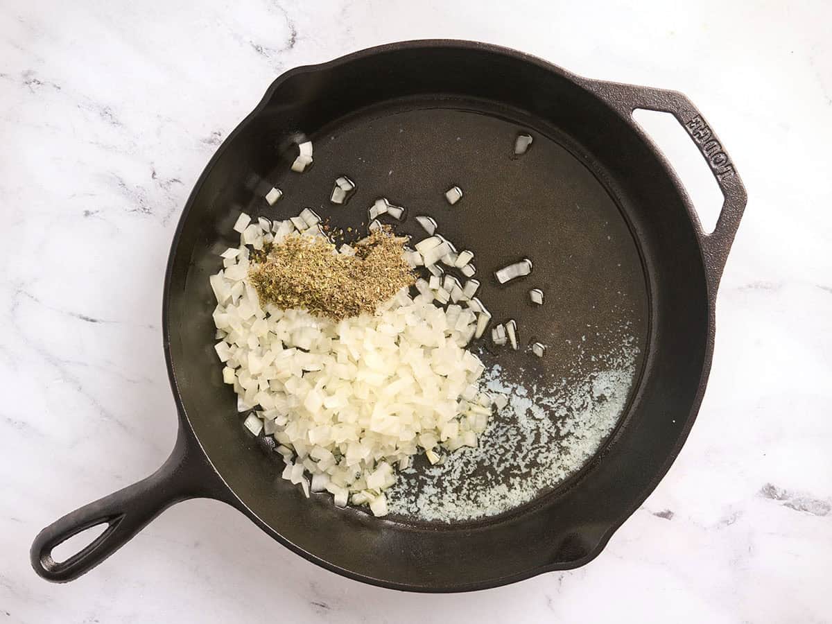 Beurre fondu, huile, oignons et herbes séchées dans une poêle.