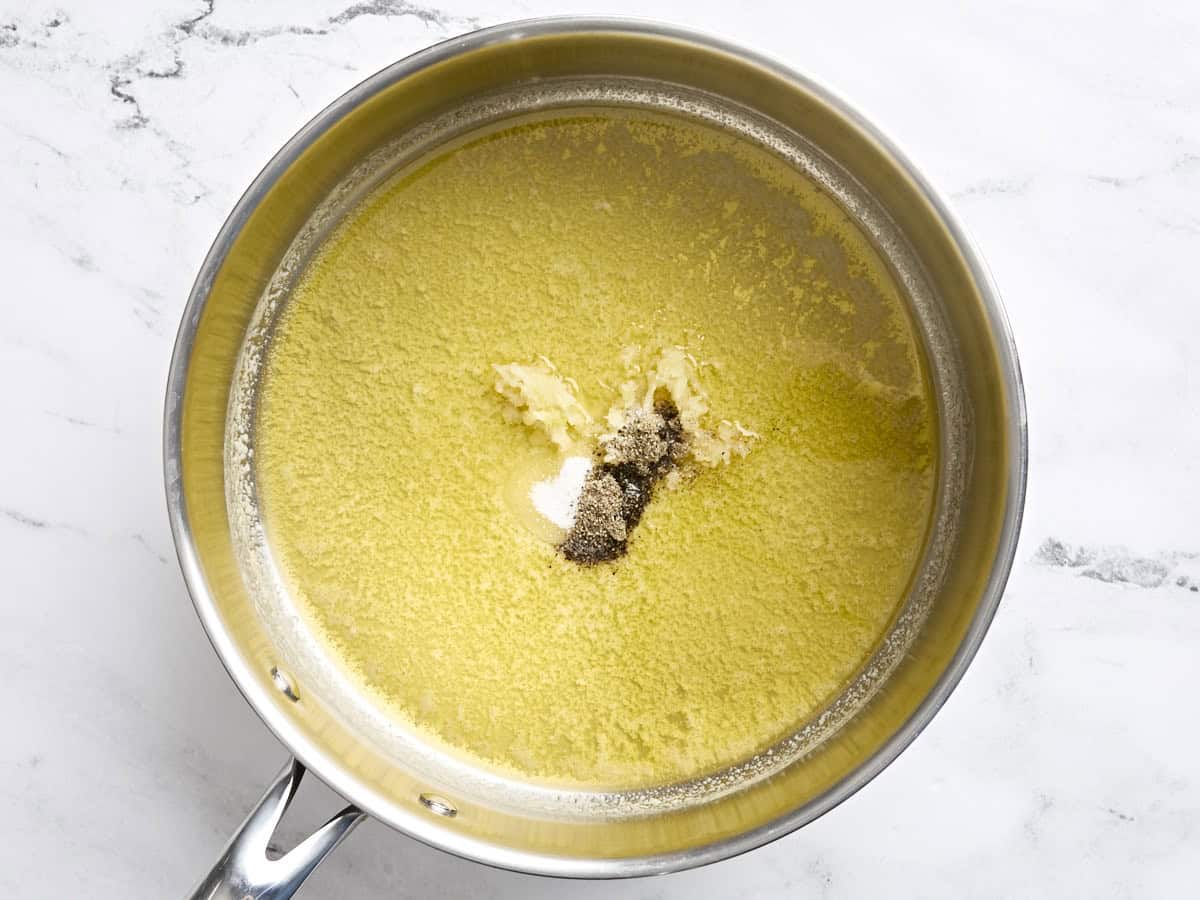 Beurre fondu dans une poêle avec du sel, du poivre et de l'ail émincé.