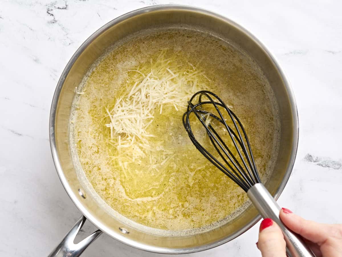 Fromage parmesan ajouté à une sauce Alfredo traditionnelle.
