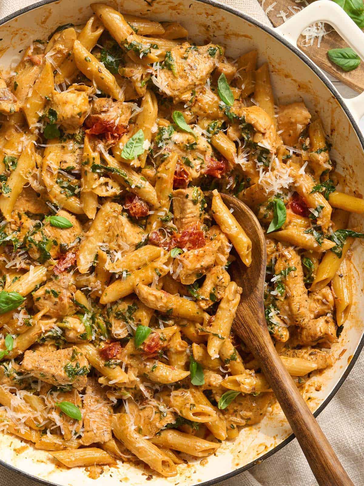 Au-dessus de épousez-moi des pâtes au poulet dans une casserole avec une cuillère en bois.