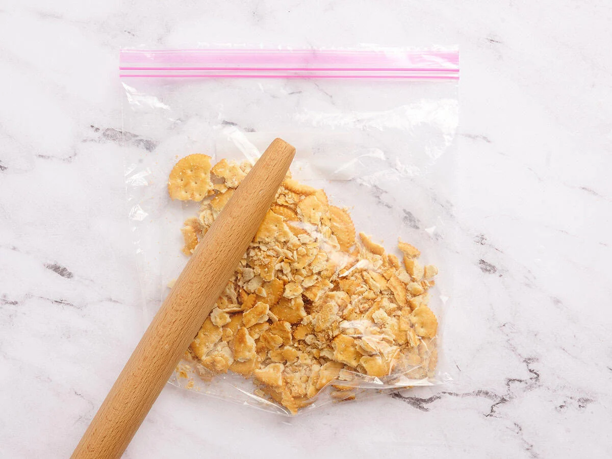 Craquelins dans un sac zippé écrasés avec un rouleau à pâtisserie.