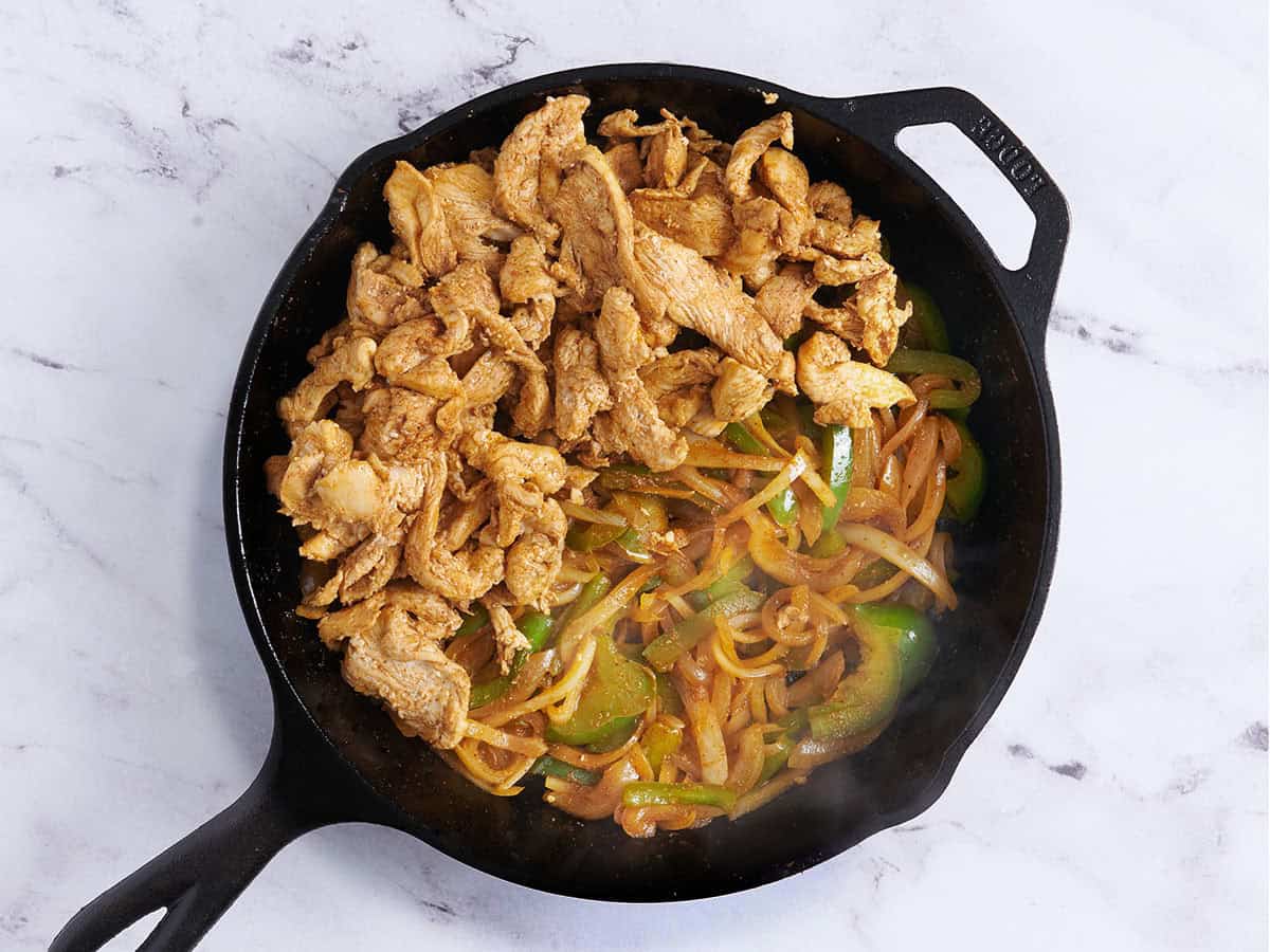 Fajita au poulet sur la cuisinière remplissant une poêle.