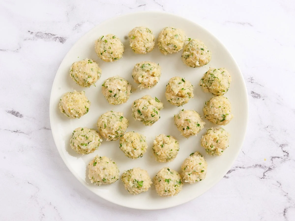 Boulettes de poulet piccata avant cuisson sur une assiette.