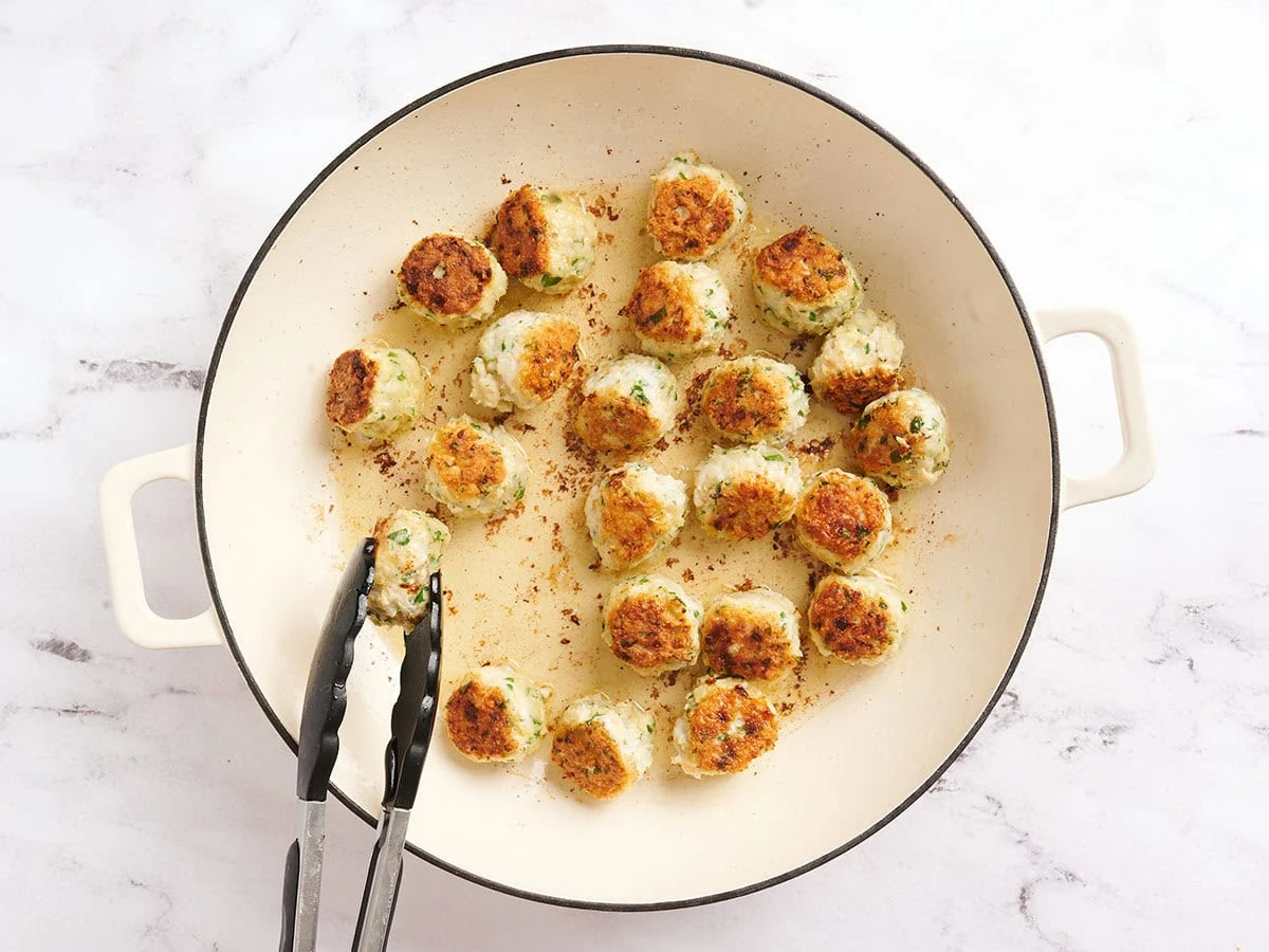 Boulettes de poulet piccata dans une poêle.