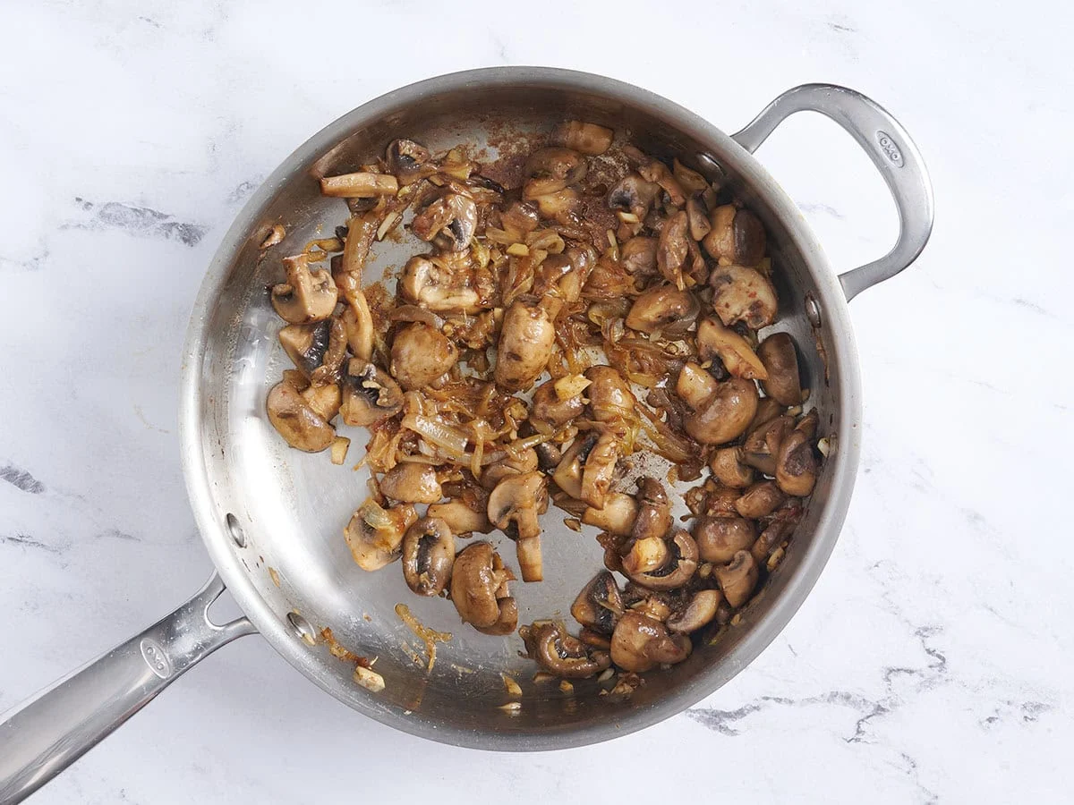 Oignons, ail et champignons dans une poêle.