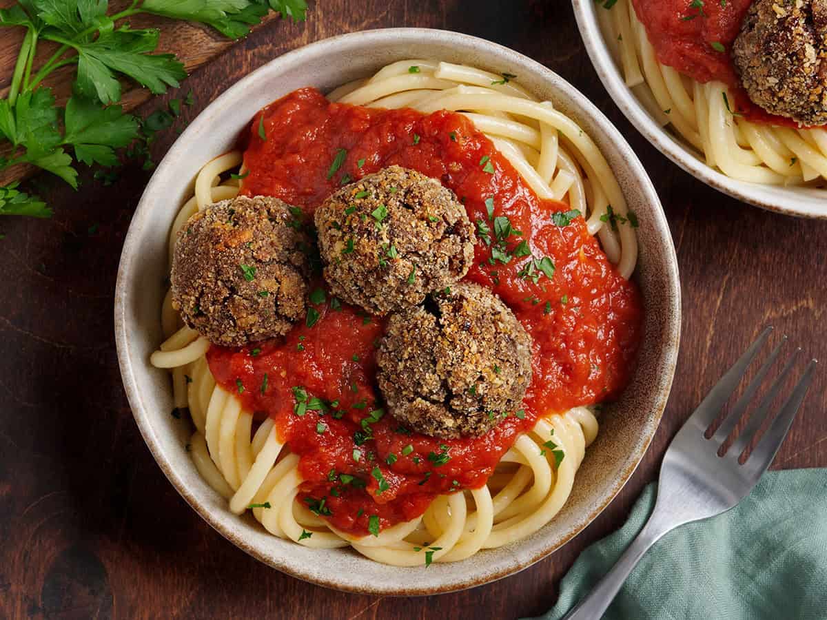 Vue aérienne de boulettes de viande végétariennes dans un bol avec spaghetti et sauce tomate.