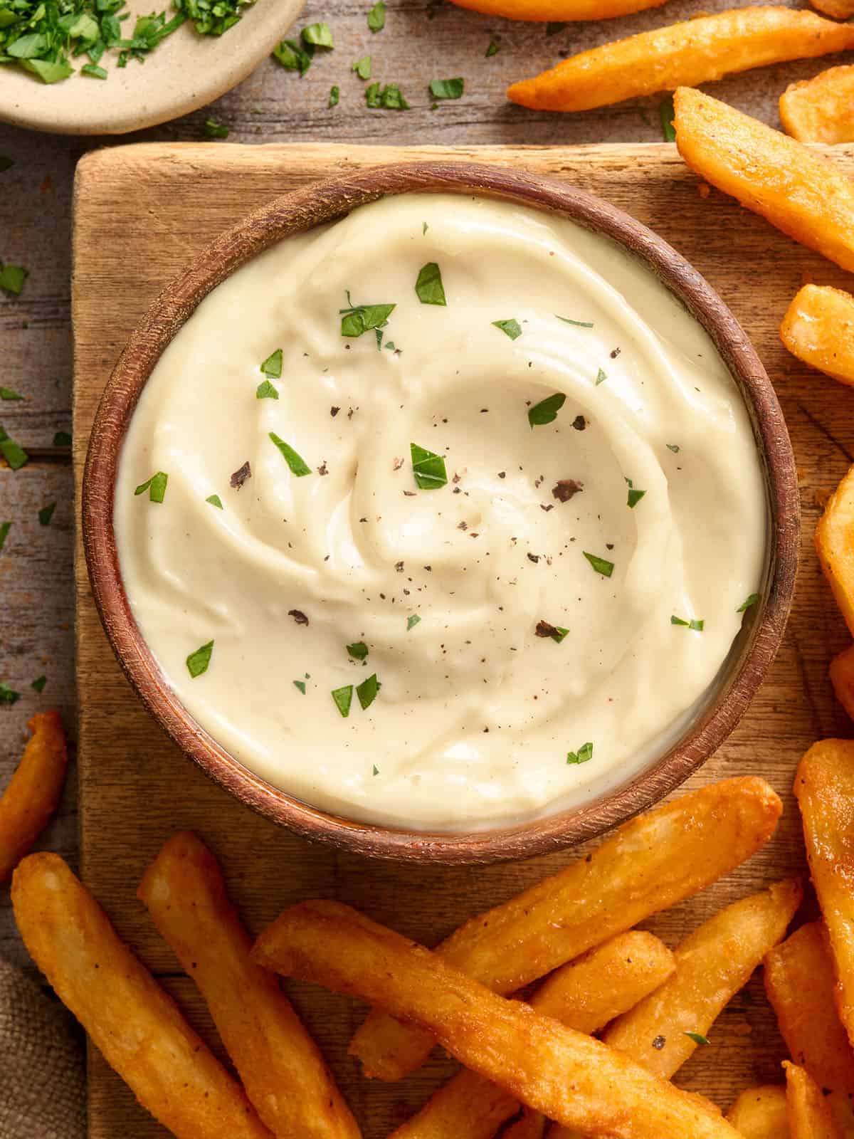 Vue aérienne d'un bol d'aïoli à l'ail maison avec frites.