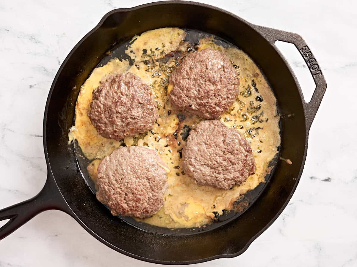 Galettes lucy juteuses cuisant dans une poêle.