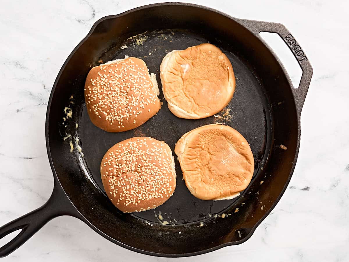 Pains à hamburger grillés dans une poêle.