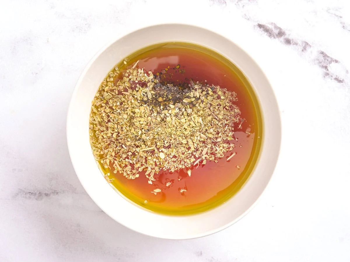 Les ingrédients de la vinaigrette pour la salade de concombre et de tomates dans un bol.