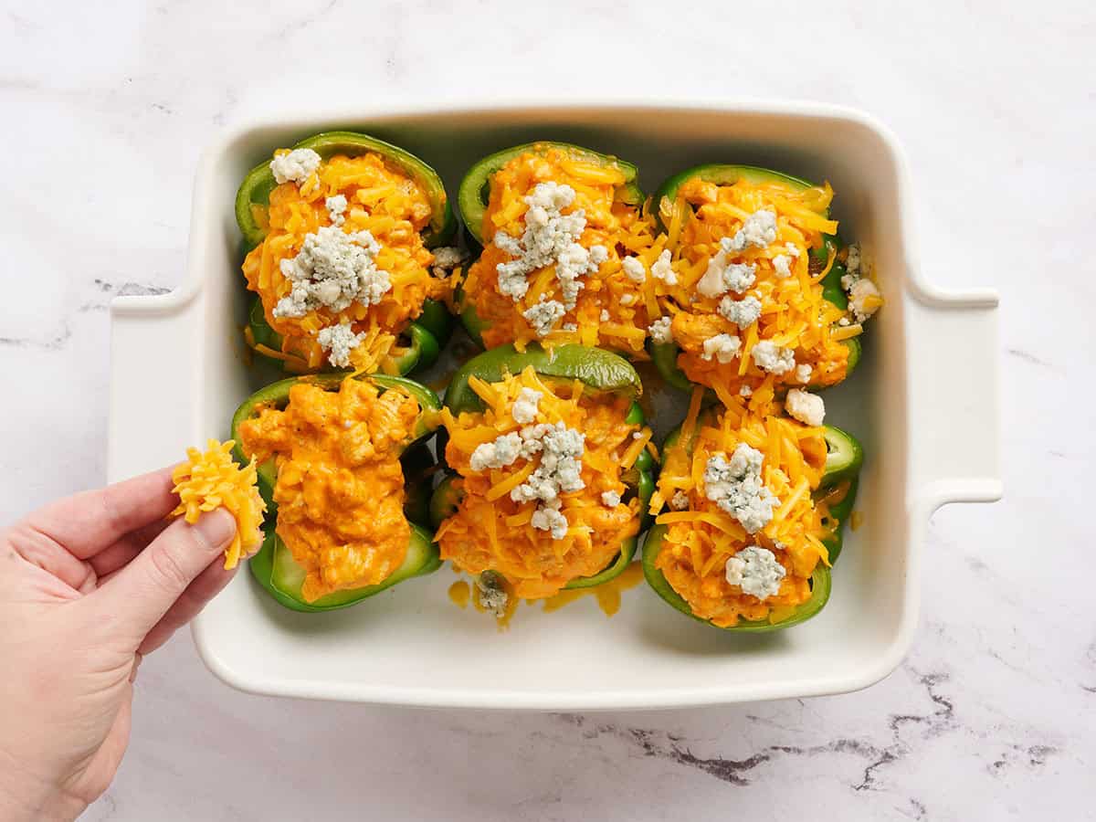 Moitiés de poivron vert farcies de poulet Buffalo, saupoudrées à la main de fromage cheddar et de fromage bleu.