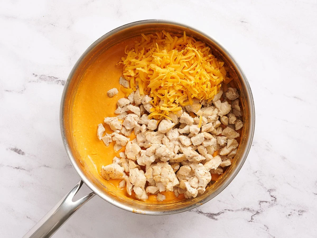 Poulet cuit, fromage râpé et sauce buffalo dans une casserole.