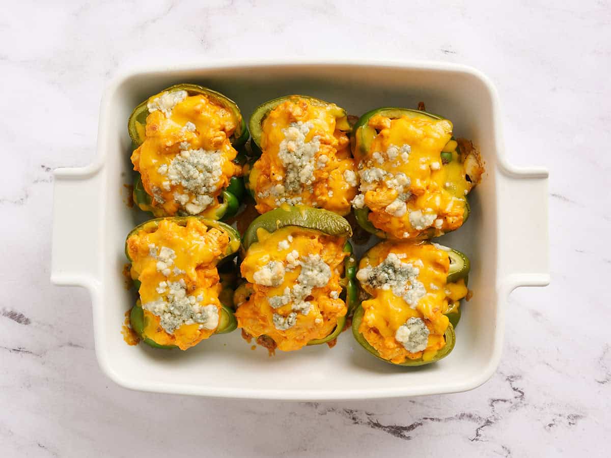Poivrons farcis au poulet Buffalo garnis d'oignons verts.