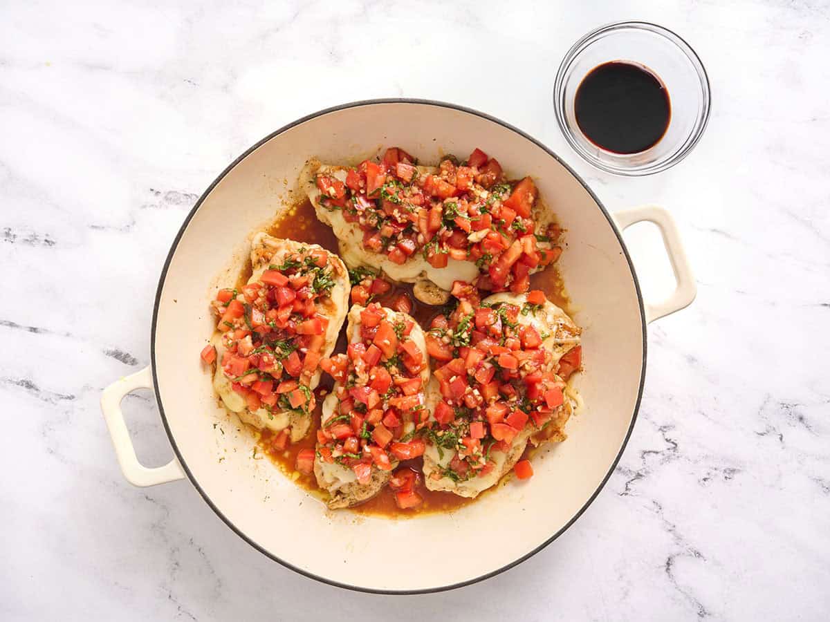 Escalopes de poulet dans une poêle garnies de bruschetta.