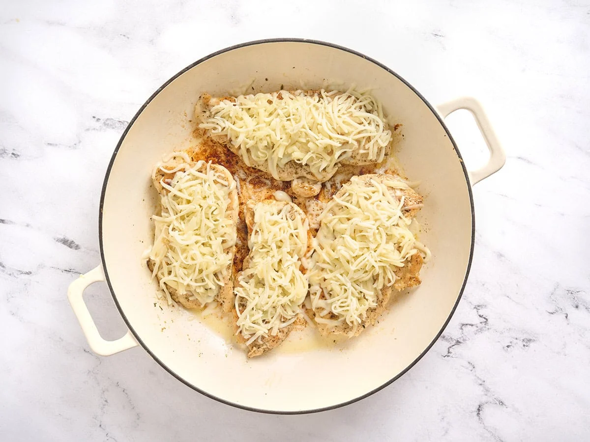Culets de poulet garnis de mozzarella dans une poêle.