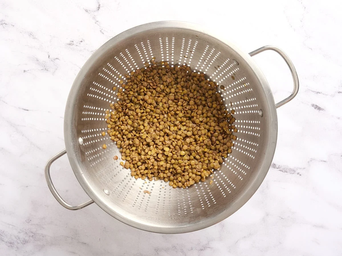 Lentilles brunes cuites dans une passoire.