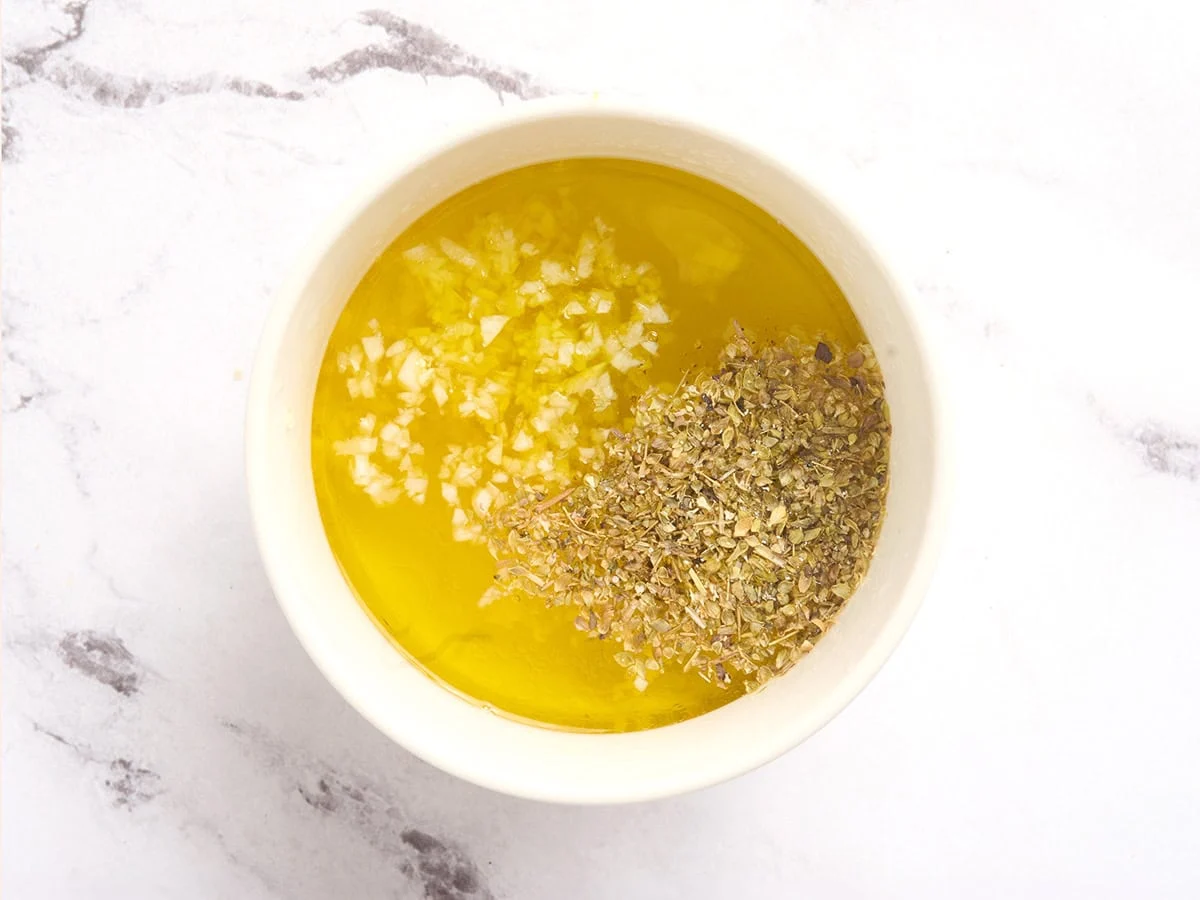 Les ingrédients pour faire une vinaigrette citron-ail dans un bol.