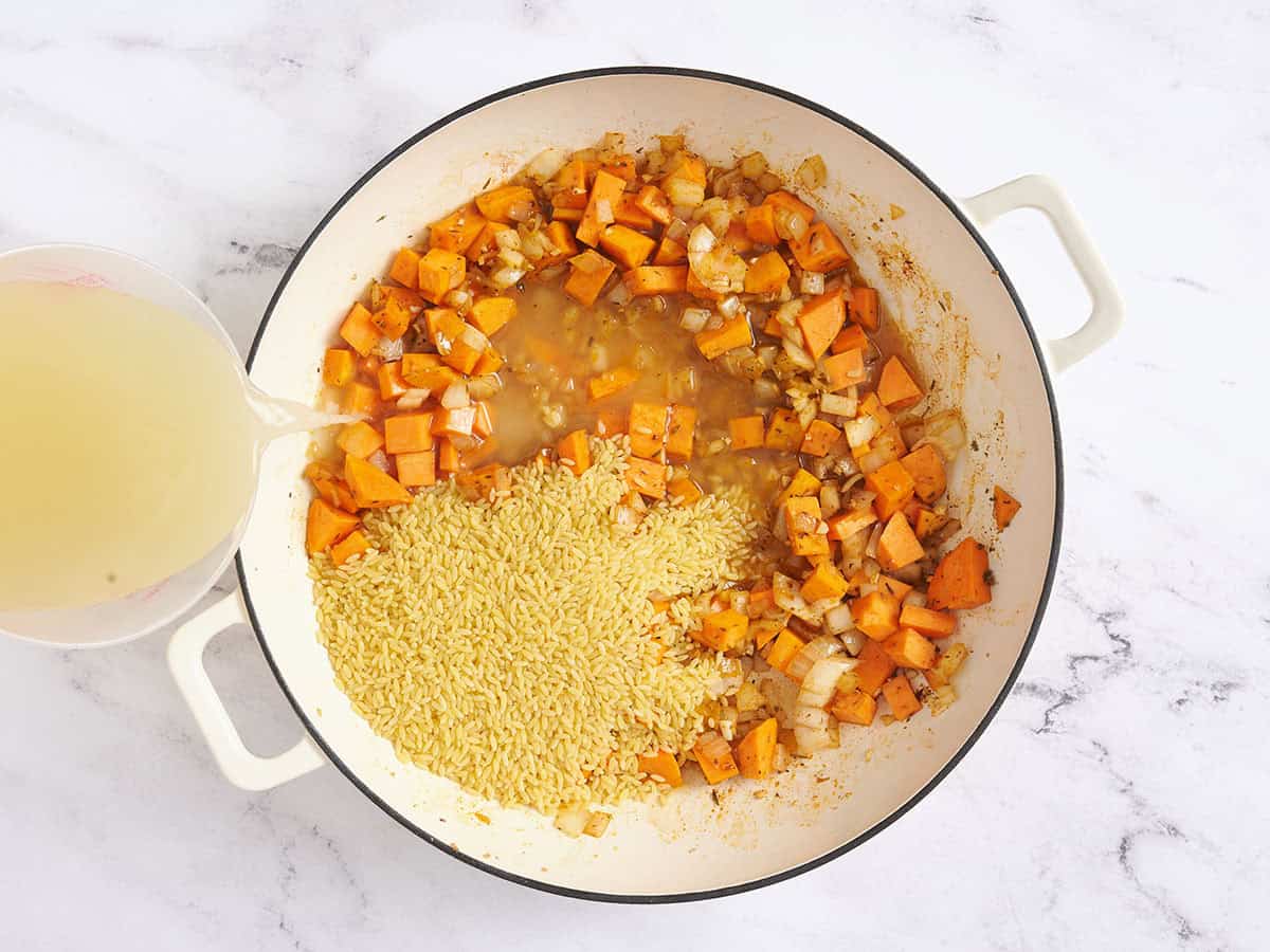 Bouillon versé dans une poêle de patates douces.