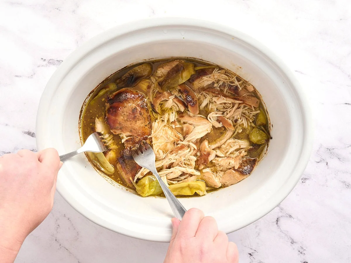 Forks râpé le poulet du Mississippi dans une mijoteuse.