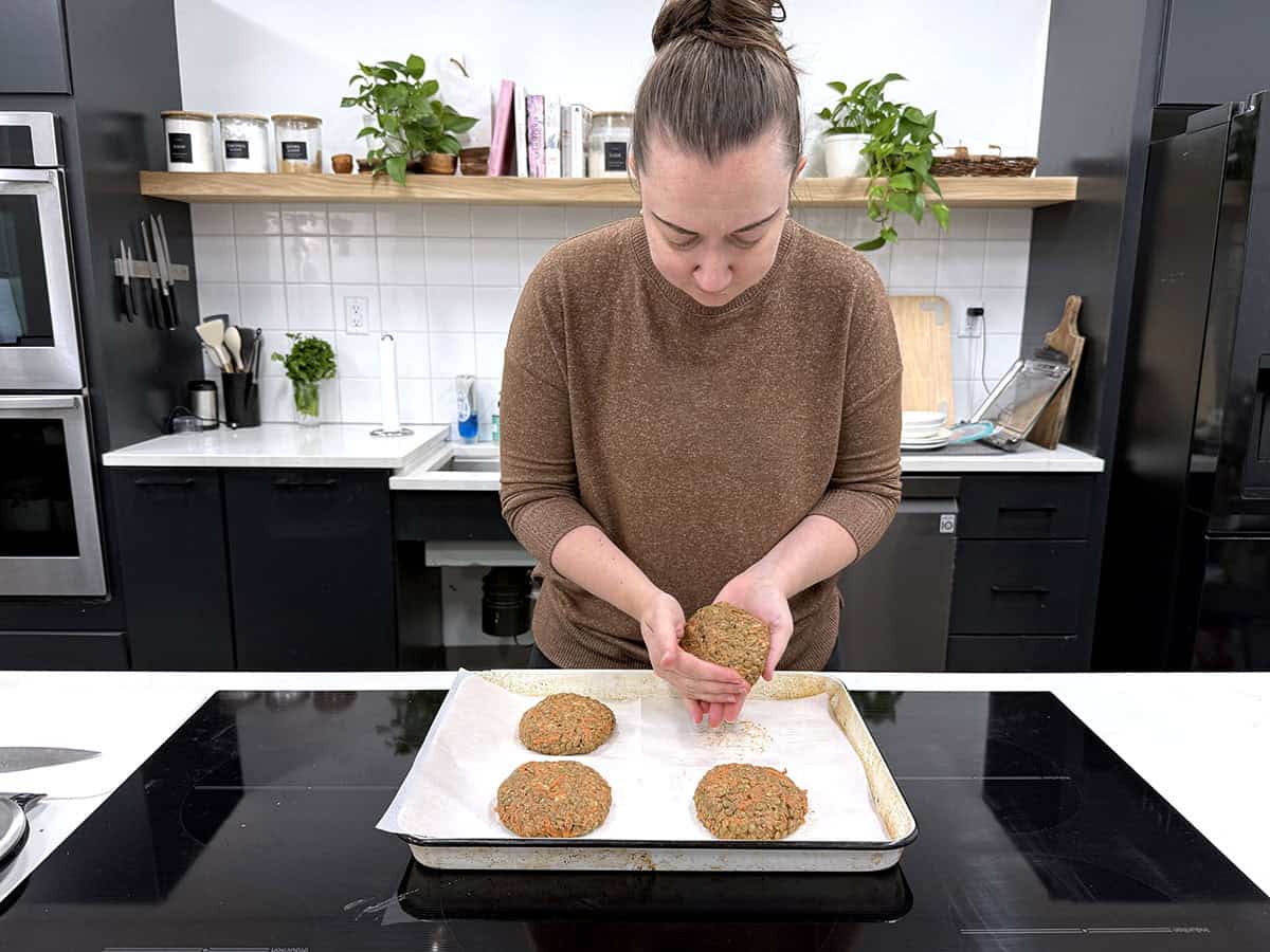 Une femme façonnant des hamburgers aux lentilles dans une cuisine.